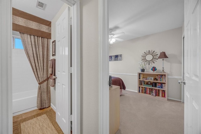 hallway featuring light colored carpet