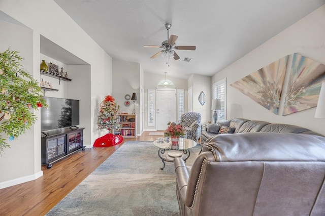 living room with ceiling fan, hardwood / wood-style floors, and vaulted ceiling