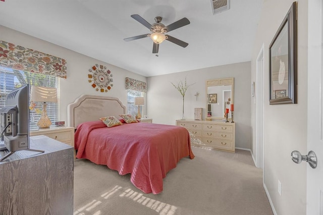 carpeted bedroom featuring multiple windows and ceiling fan