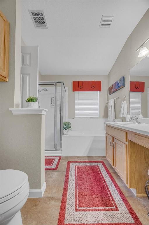 full bathroom with tile patterned flooring, shower with separate bathtub, vanity, and toilet