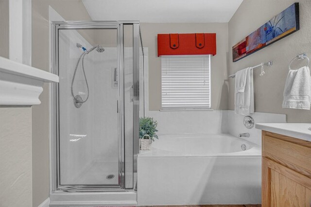 bathroom featuring vanity and independent shower and bath