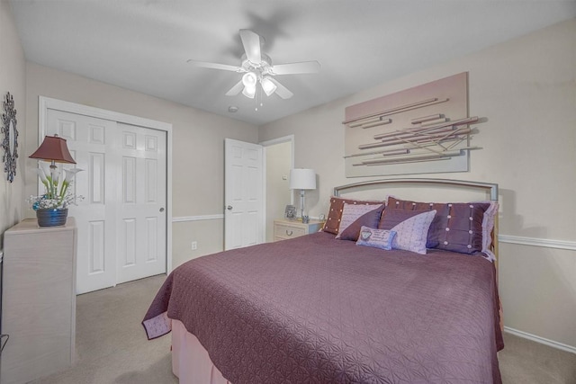 bedroom with ceiling fan, light carpet, and a closet