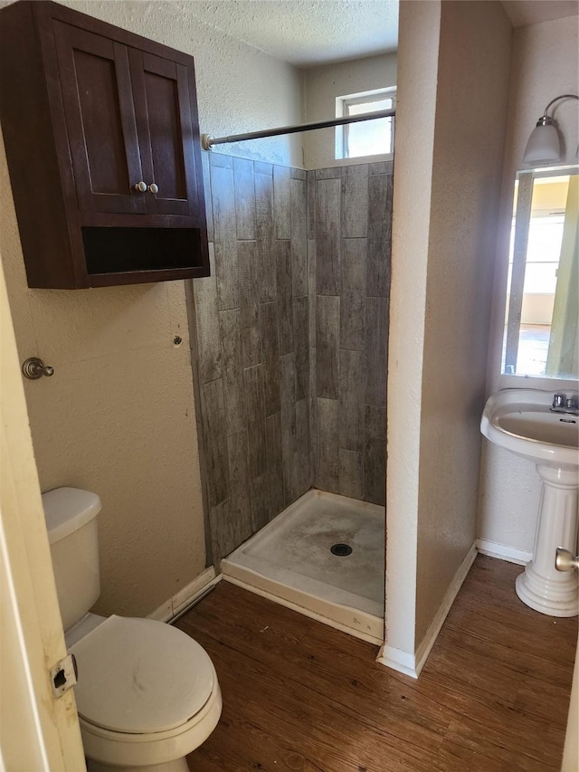 bathroom featuring wood-type flooring, toilet, and walk in shower