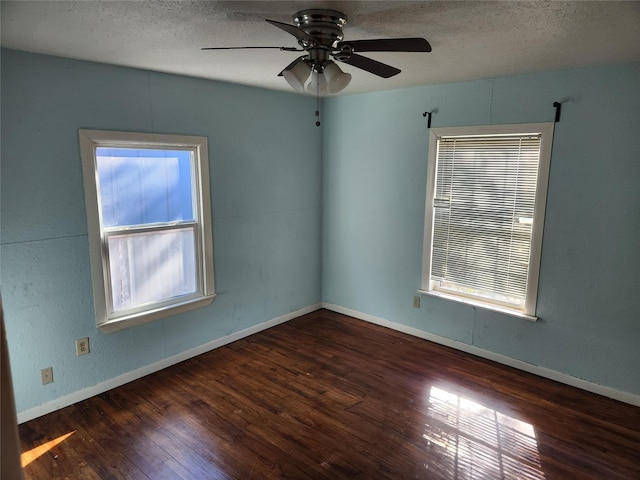 empty room featuring ceiling fan, dark hardwood / wood-style floors, and a textured ceiling