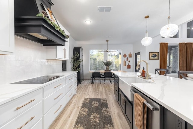 kitchen featuring dishwasher, white cabinets, black electric stovetop, and pendant lighting