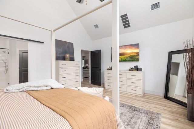 bedroom featuring high vaulted ceiling and light hardwood / wood-style floors