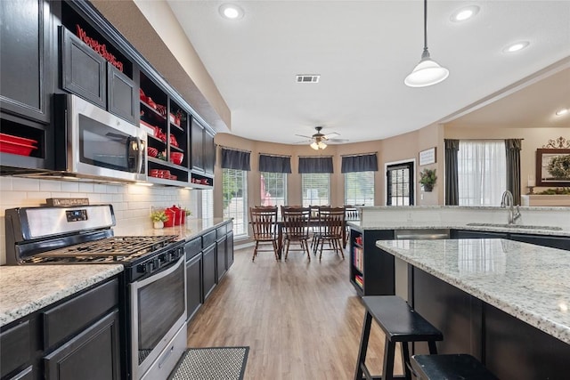 kitchen featuring sink, plenty of natural light, decorative light fixtures, and appliances with stainless steel finishes