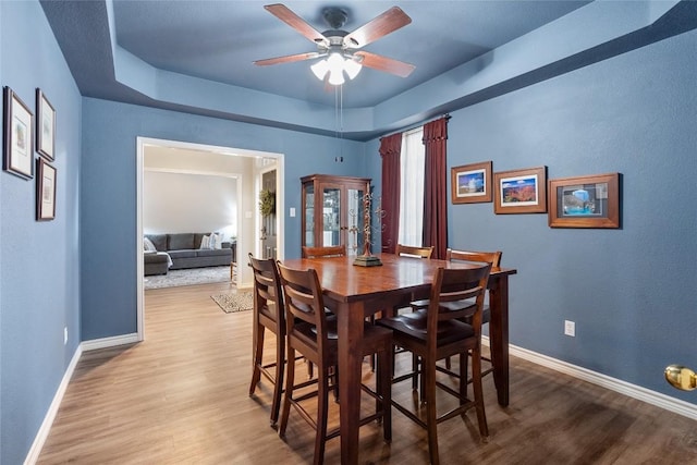 dining space with ceiling fan and wood-type flooring