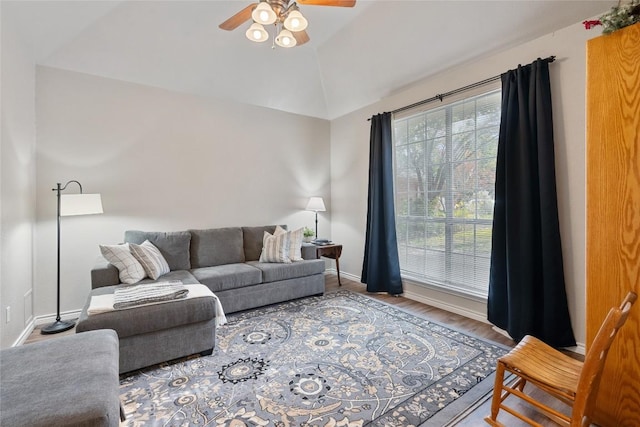 living room with hardwood / wood-style floors, ceiling fan, and vaulted ceiling