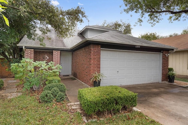 12809 Meehan Dr, Austin, TX 78727 - view of front facade with brick siding, a garage, concrete driveway, and roof with shingles