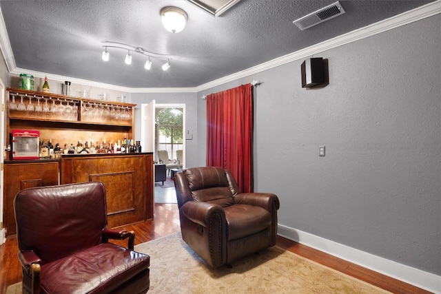 12809 Meehan Dr, Austin, TX 78727 - indoor dry bar with wood finished floors, ornamental molding, a textured ceiling, and a textured wall