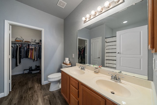 bathroom with wood-type flooring, vanity, and toilet