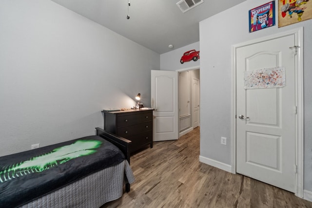 bedroom featuring light hardwood / wood-style flooring and lofted ceiling