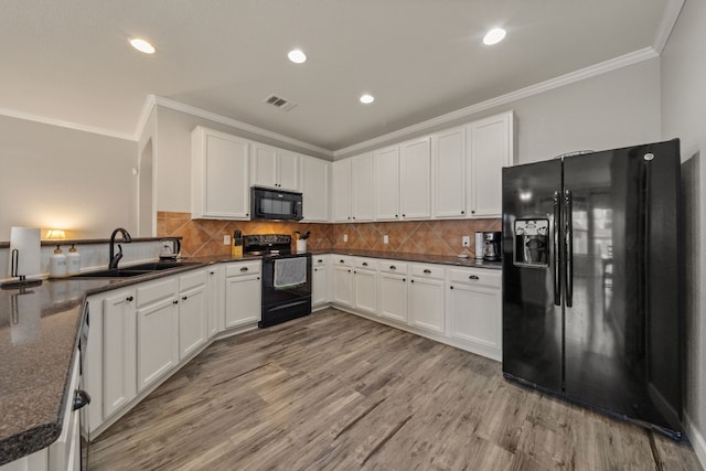 kitchen with white cabinets, sink, light hardwood / wood-style floors, and black appliances