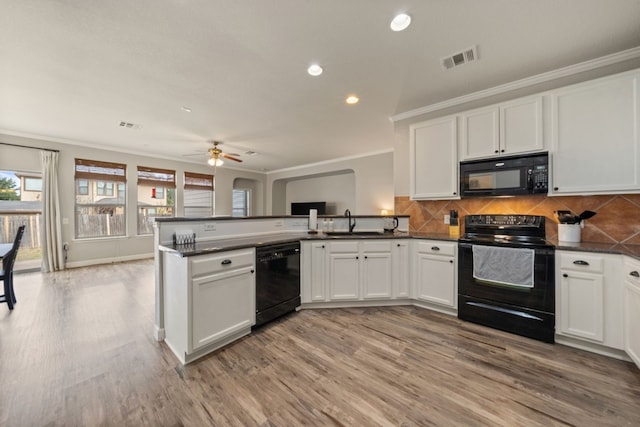 kitchen with black appliances, light wood-type flooring, and white cabinetry