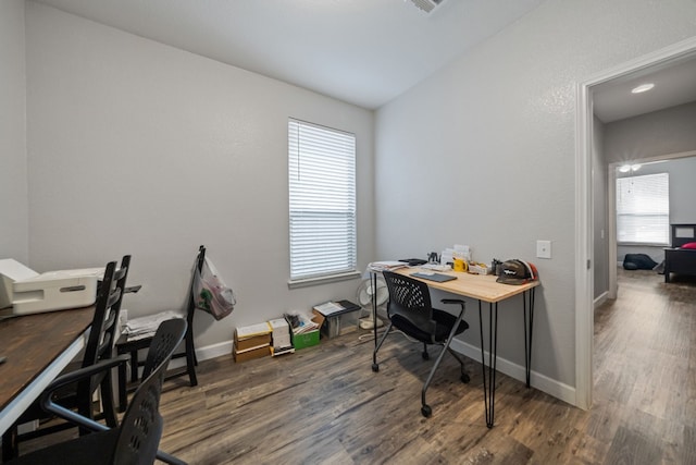 office space with dark hardwood / wood-style flooring, a healthy amount of sunlight, and vaulted ceiling