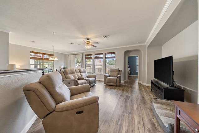 living room featuring hardwood / wood-style flooring, ceiling fan with notable chandelier, and ornamental molding