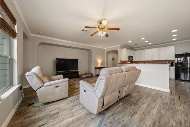 living room with light hardwood / wood-style floors, plenty of natural light, and ornamental molding