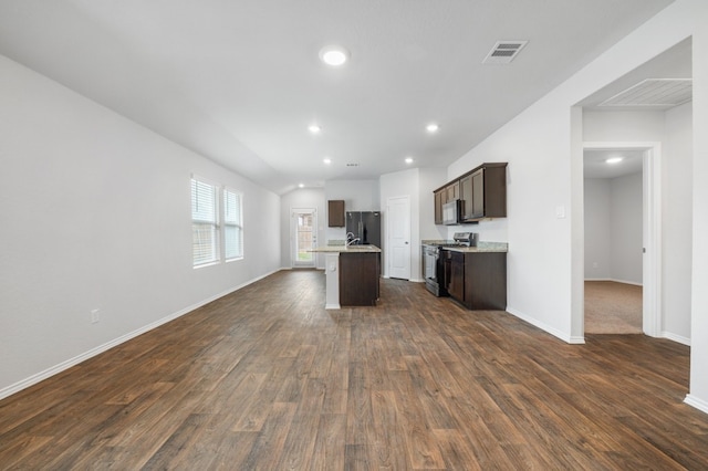 kitchen featuring black fridge, dark hardwood / wood-style floors, dark brown cabinets, stainless steel stove, and a center island with sink