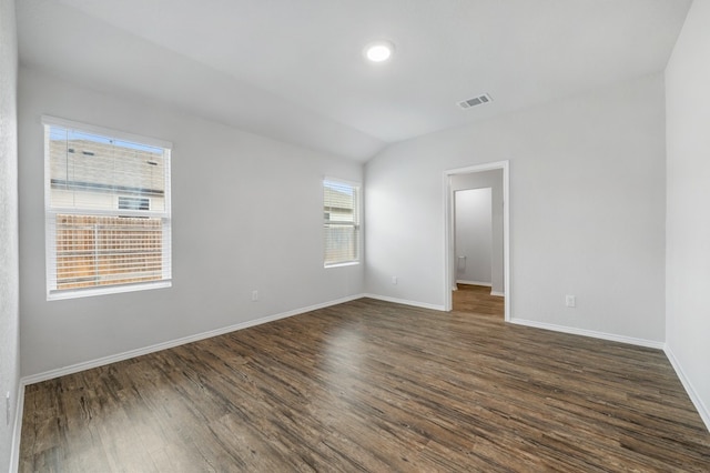 empty room with dark hardwood / wood-style floors and vaulted ceiling