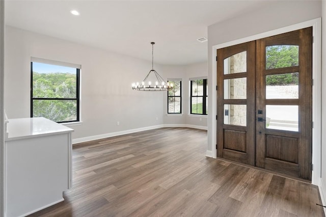 entryway featuring hardwood / wood-style floors, an inviting chandelier, and french doors