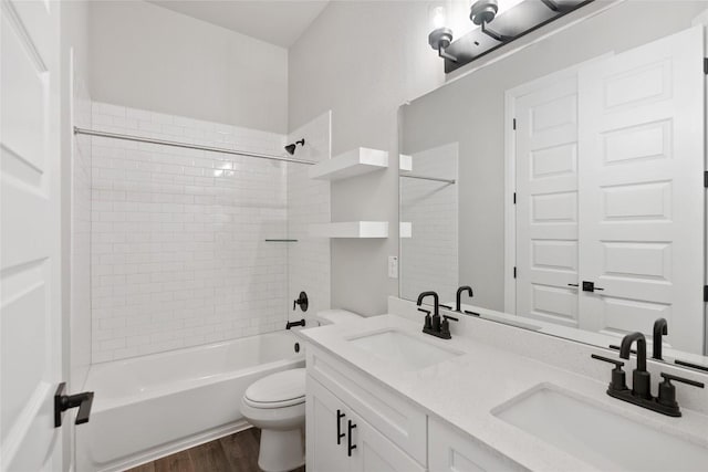 full bathroom featuring tiled shower / bath, wood-type flooring, toilet, and vanity