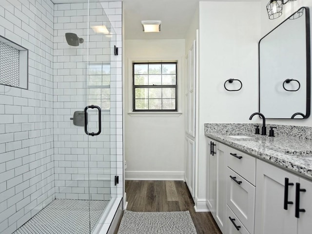 bathroom with hardwood / wood-style floors, vanity, and walk in shower