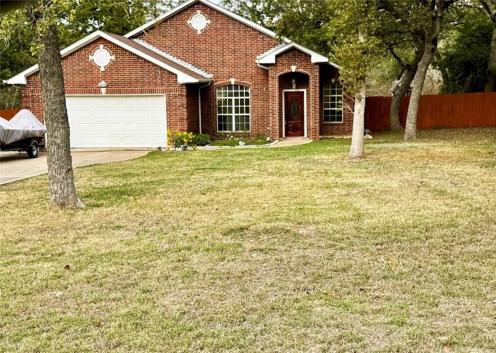 single story home featuring a front lawn and a garage