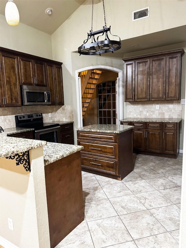 kitchen featuring decorative light fixtures, dark brown cabinets, and stainless steel appliances