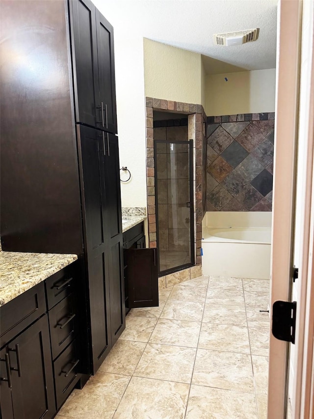 bathroom with vanity, shower with separate bathtub, and a textured ceiling