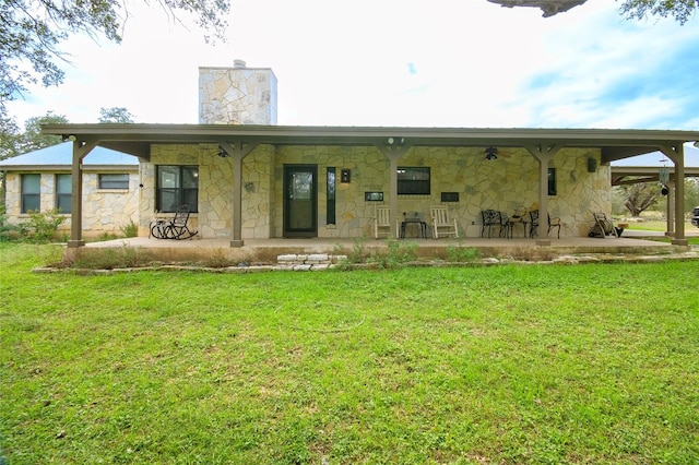 rear view of property featuring a lawn