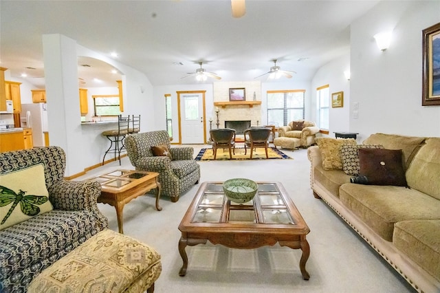 carpeted living room featuring a fireplace and vaulted ceiling