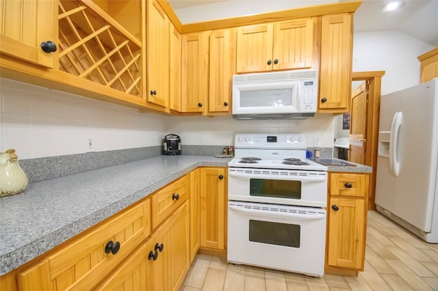 kitchen with decorative backsplash, white appliances, light hardwood / wood-style floors, and vaulted ceiling