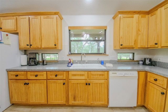 kitchen featuring sink, light tile patterned floors, and white appliances