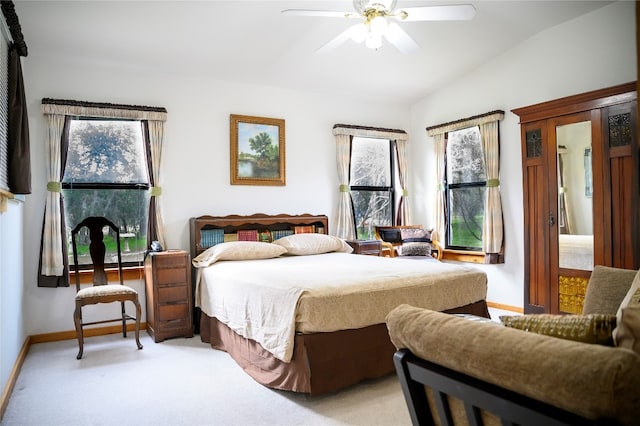 bedroom with ceiling fan, light colored carpet, and vaulted ceiling