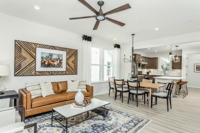 living room with ceiling fan and light wood-type flooring