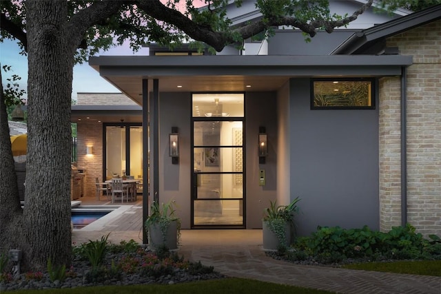 exterior entry at dusk featuring a patio