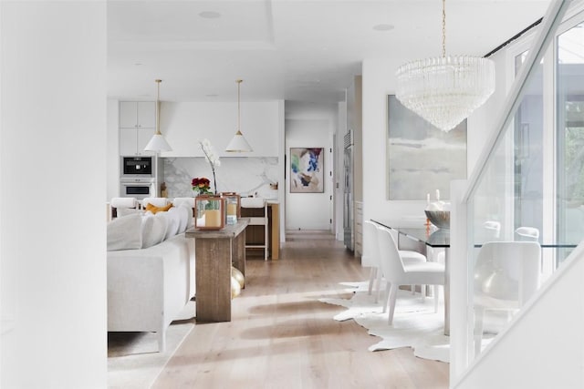 living room featuring light hardwood / wood-style floors and an inviting chandelier