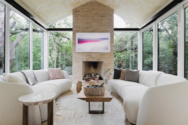 sunroom / solarium featuring a fireplace, plenty of natural light, and lofted ceiling