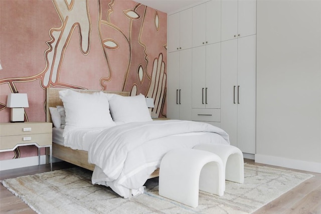 bedroom with light hardwood / wood-style floors and a closet