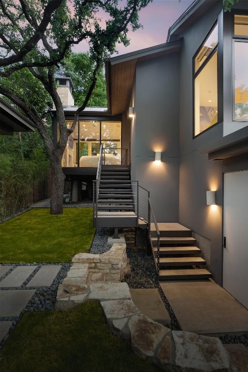 exterior entry at dusk with a lawn