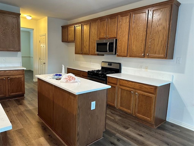 kitchen with gas stove, a center island, and dark hardwood / wood-style floors