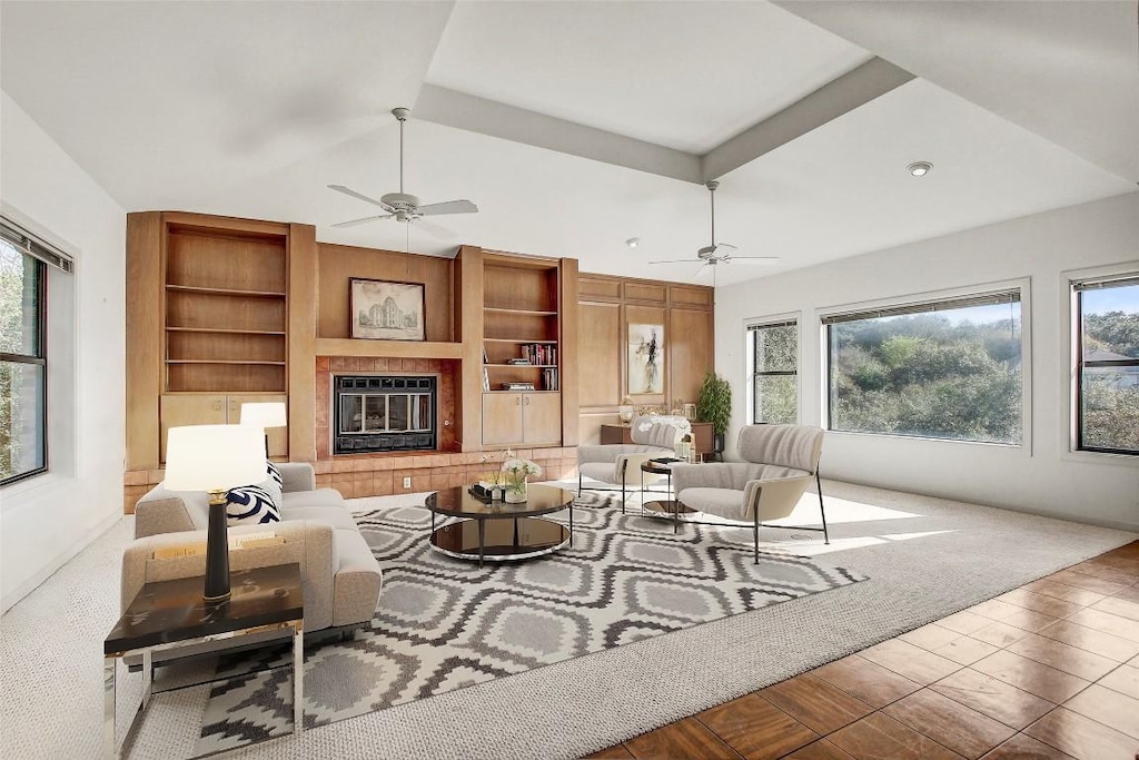 living room with plenty of natural light, wood-type flooring, and a tile fireplace