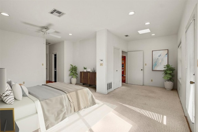 carpeted bedroom featuring ceiling fan and a skylight