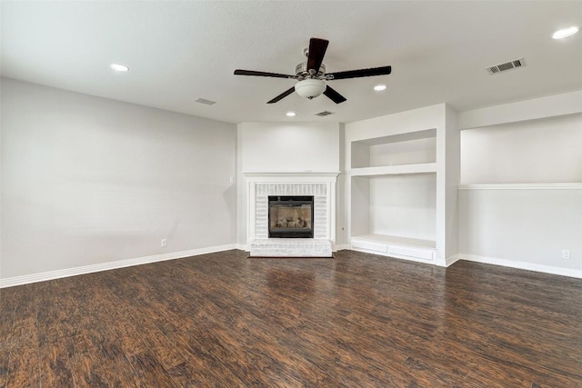 unfurnished living room featuring ceiling fan, a fireplace, wood-type flooring, and built in features