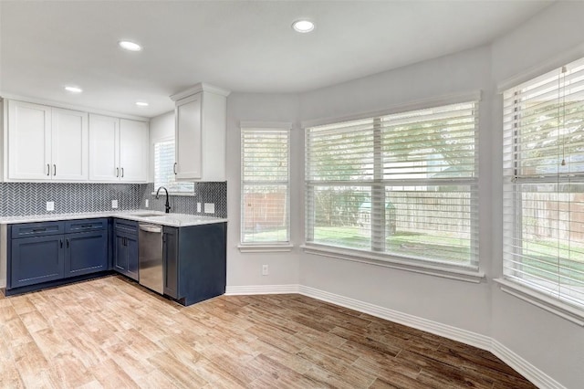 kitchen featuring white cabinets, a healthy amount of sunlight, stainless steel dishwasher, and light wood-type flooring