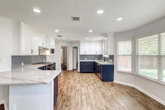 kitchen featuring kitchen peninsula, light wood-type flooring, white cabinetry, and sink