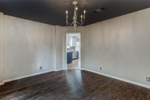 unfurnished dining area with dark hardwood / wood-style floors and a notable chandelier