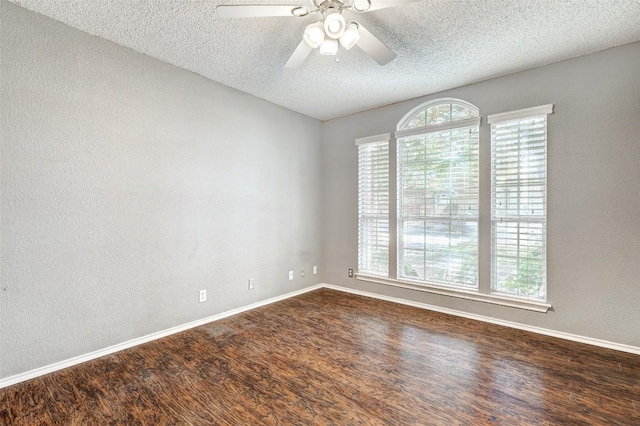 unfurnished room featuring a textured ceiling, ceiling fan, and dark wood-type flooring