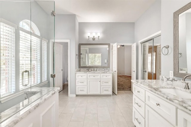 bathroom with tile patterned flooring, vanity, and a healthy amount of sunlight